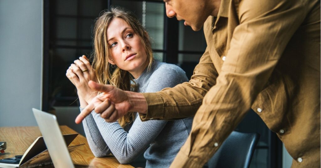 woman and man discussing something. man is pointing at a nonvisibile laptop screen while woman looks at his face