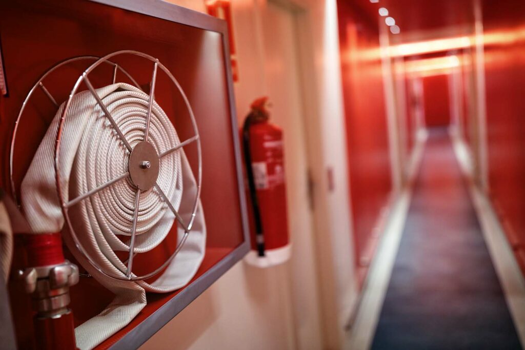 Fire extinguisher and fire hose placed in a hallway and monitored by the CIMAG Access security and emergency system modules