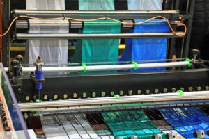 rolls of multiple colored plastic bags on a production machine at a plastic manufacturing company representing the chemical & plastics industries