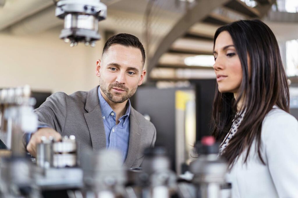 two factory managers examining factory work products for scrap and rework