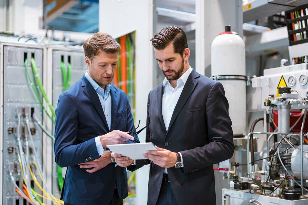 Factory executives reviewing long term planning configurations on a tablet